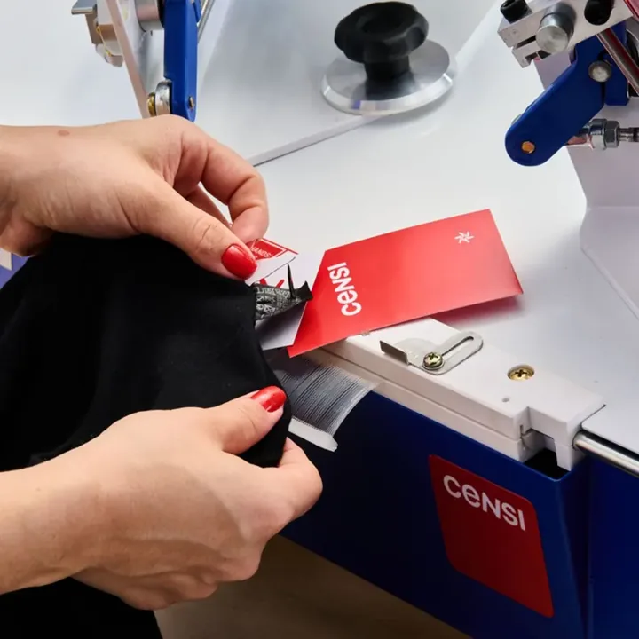 Tagpress Censi aplicando tag em camiseta preta